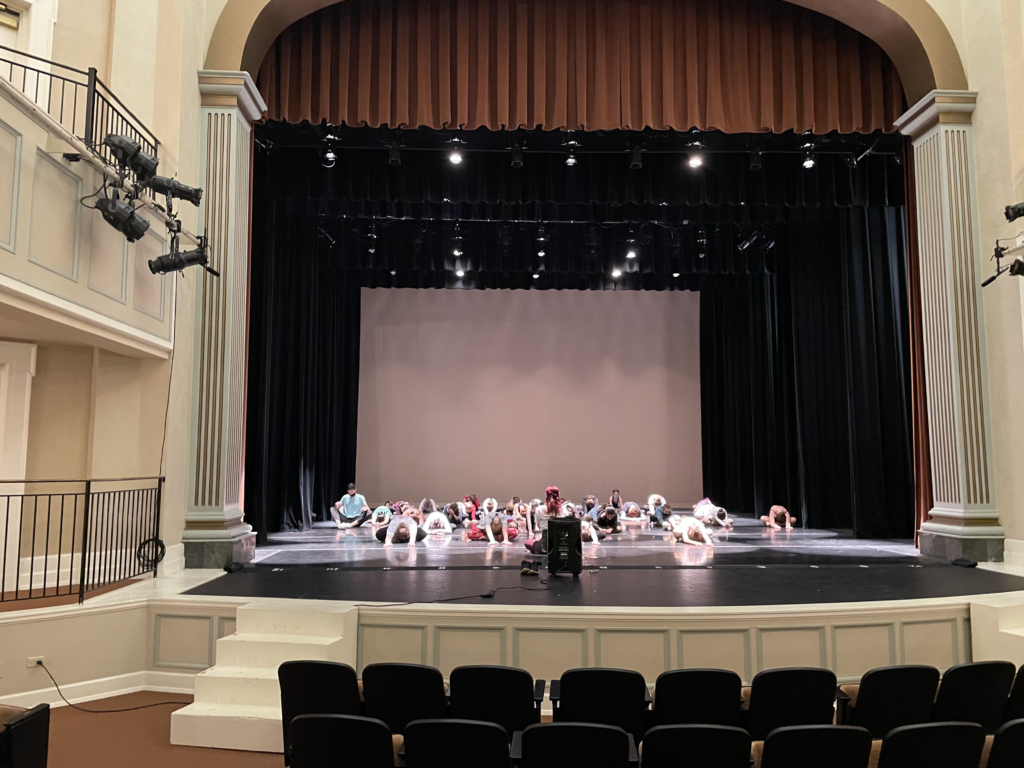 Bellevue Performing Arts Center Dance students stretching on stage before performance.